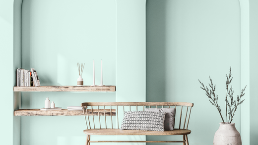 bright and airy living room with light minty aqua-coloured walls, wooden shelves and bench and neutral decoration