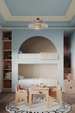 childrens bedroom in a soft pale blue room featured bunk beds and peach colours steps and a striped border design ceiling.